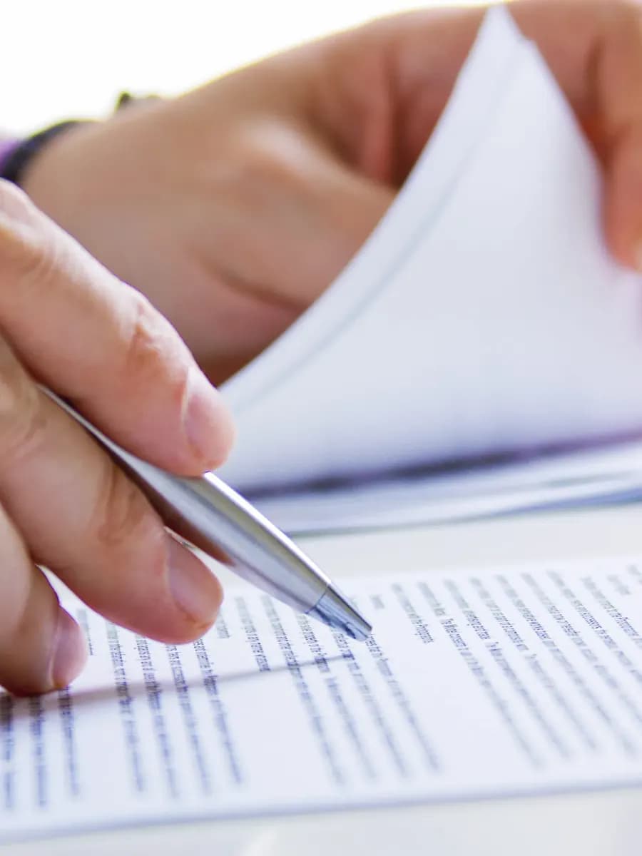 Close-up of a person reviewing a document with a pen